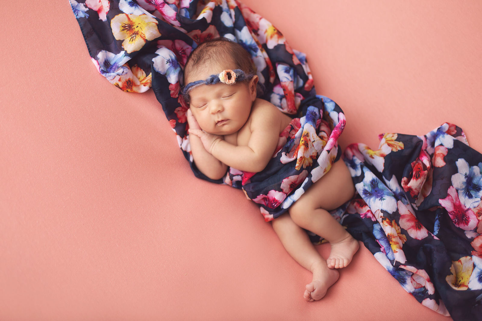 Newborn Valentina in a floral wrap and tieback during her Tucson newborn session with Belle Vie Photography