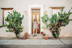 A senior portrait session for Grace in downtown Tucson standing between two large prickly pear cacti