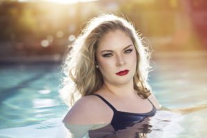 Graduating senior Olivia dons her swim team swimsuit for senior portraits in the pool