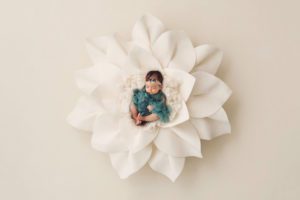 Newborn baby girl in a giant white flower