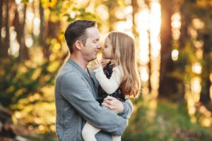 A father and his daughter playfully touch noses during their fall family session