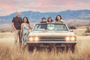 A family of five posed in and by a beloved vintage car during their family session in Sonoita