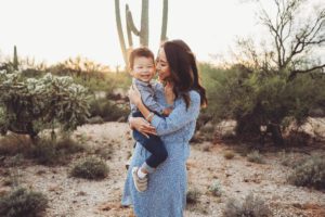 A mom holds her laughing little boy close during their family session at Saguaro National Park