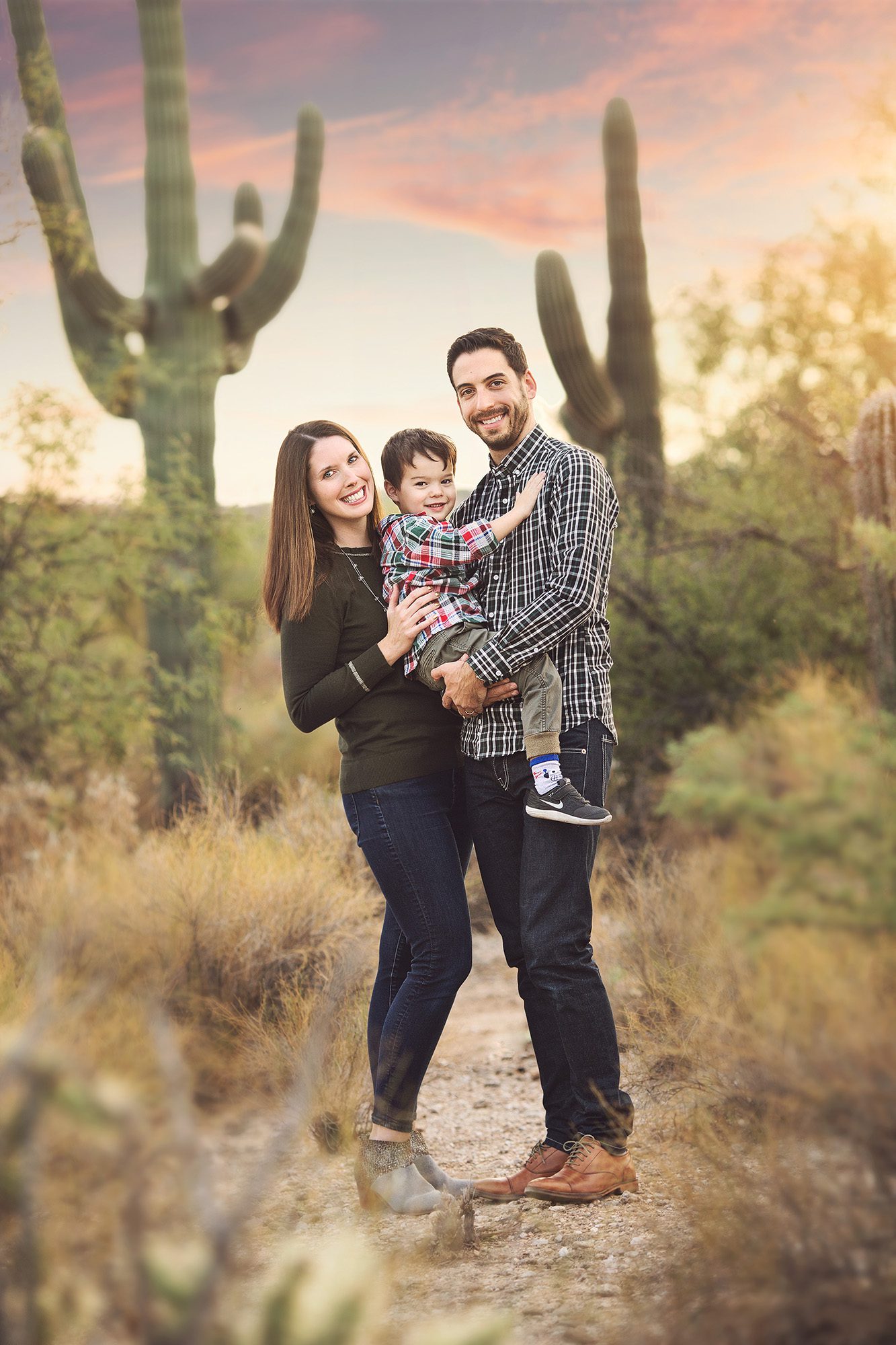 Holiday family session in Tucson with mom, dad and son in front of saguaros