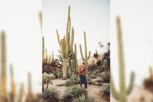 A loving smile between this couple with giant saguaros at their back during their sunset couple's session at Sabino Canyon