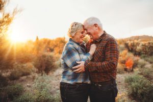 A couple celebrates their long marriage and an intimate moment at sunset during their 2018 family session at Gates Pass with Belle Vie Photography