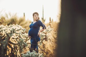 Alicia stands amongst the jumping cactus during her maternity session at Saguaro National Park