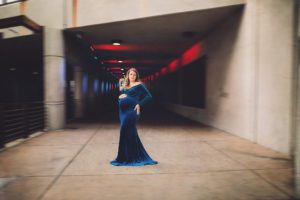 Maternity session in downtown Tucson shot in front of an underpass with red and blue lights