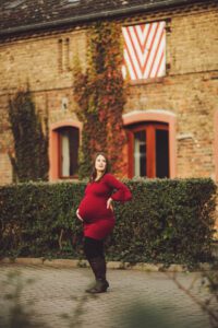 A beautiful mom in red during her fall maternity session at Domane Mechtildshausen
