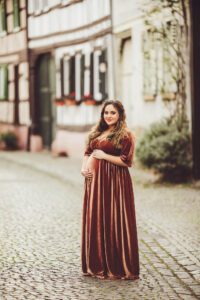 A mom looking beautiful during her maternity session in a brown velvet gown in Hochheim