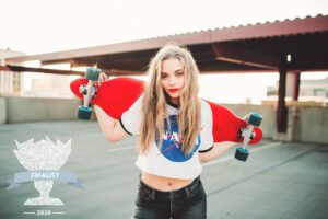 Finalist photography award for a young girl holding a skateboard on a rooftop at sunset