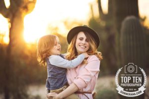 A mom and son laugh together during their sunset family photo session in Tucson