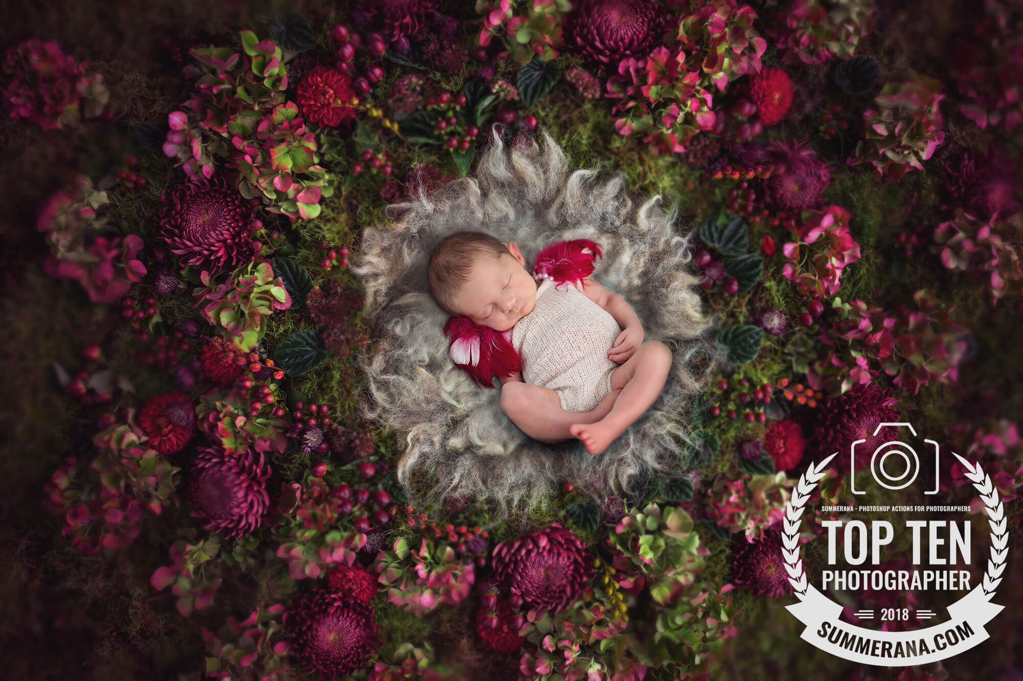 A newborn baby is surrounded by pink and green flowers during her newborn photo session in Tucson