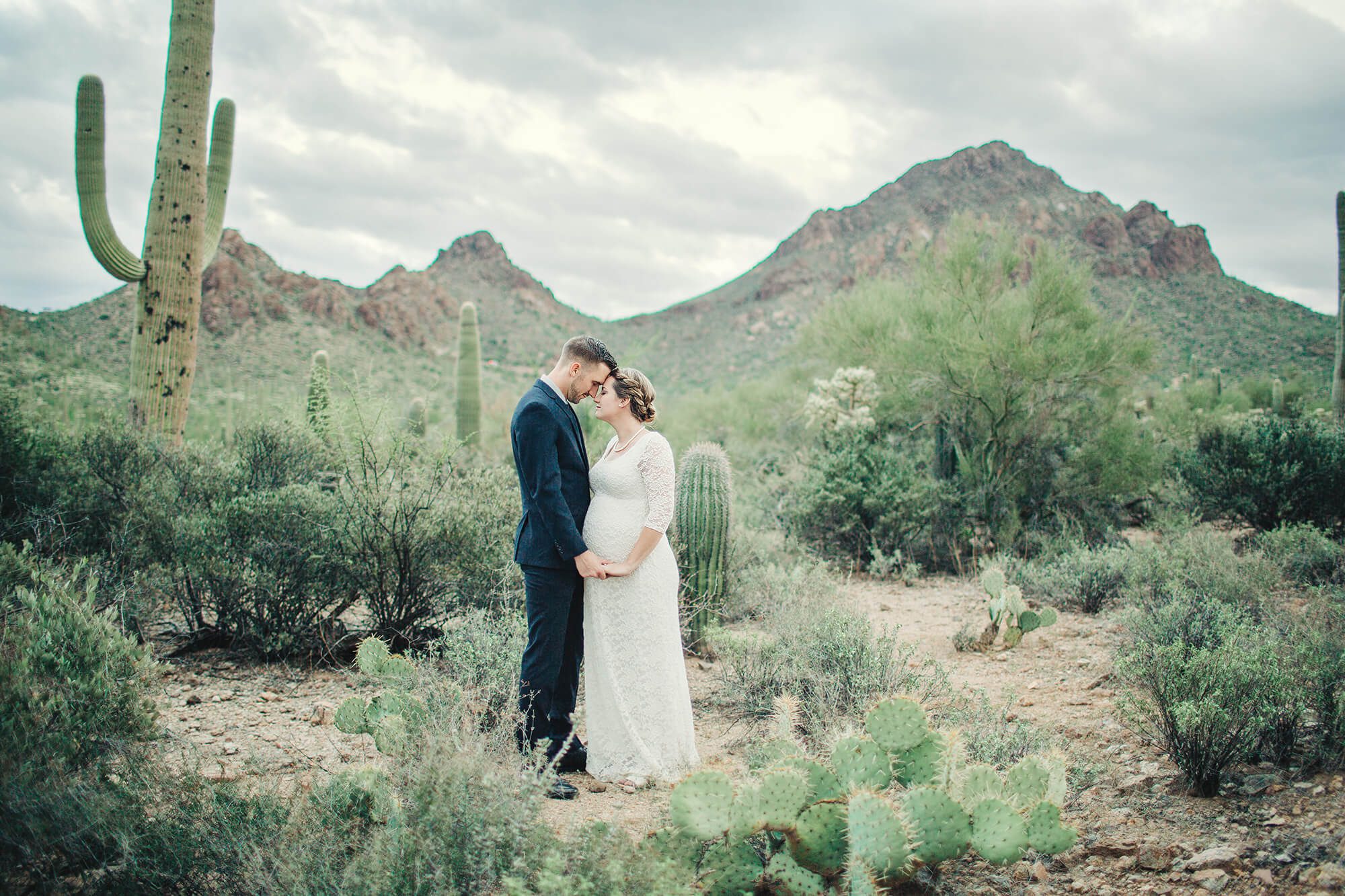 Bride and groom share a loving moment at Gate's Pass in Tucson following their desert elopement.