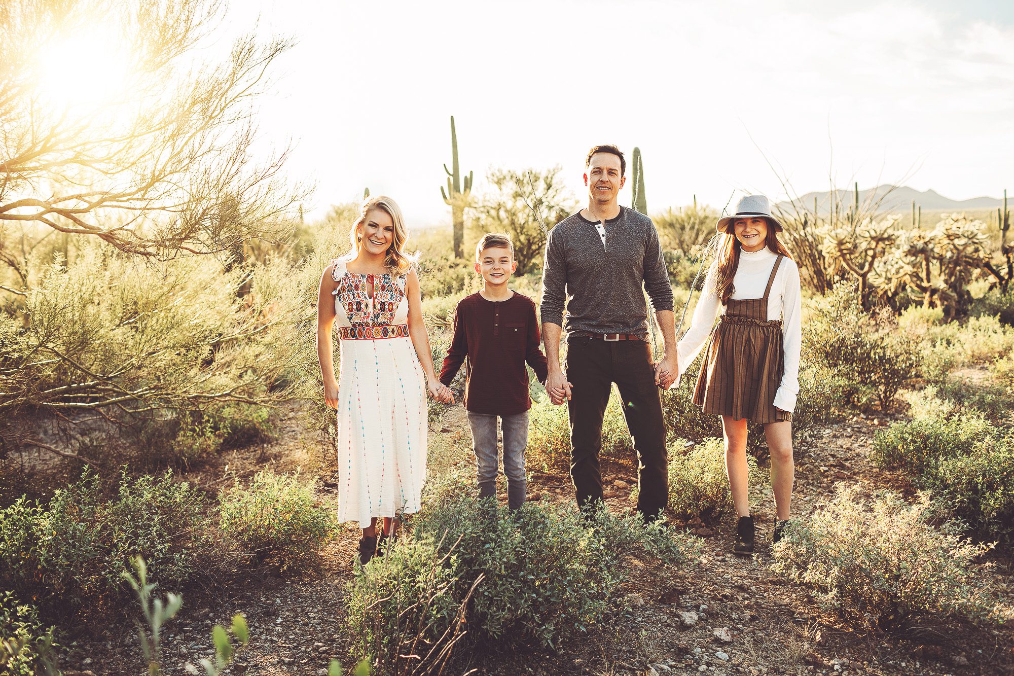 A family enjoys a beautiful winter evening in the desert during their sunset family shoot with Belle Vie Photography