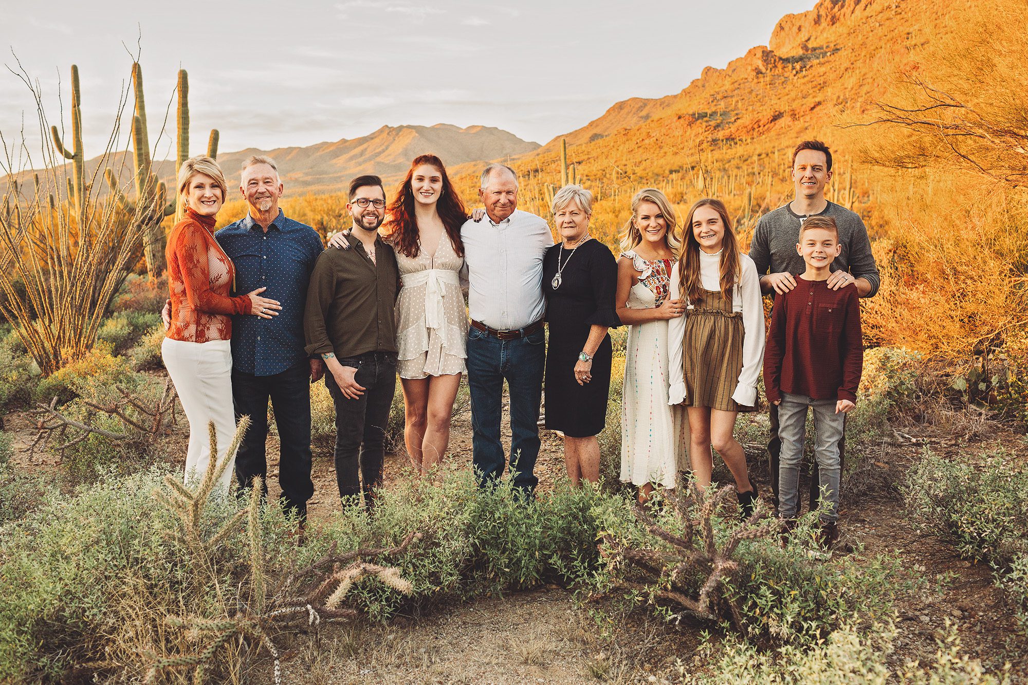 A family with three generations enjoys a beautiful desert sunset together during their family photo session