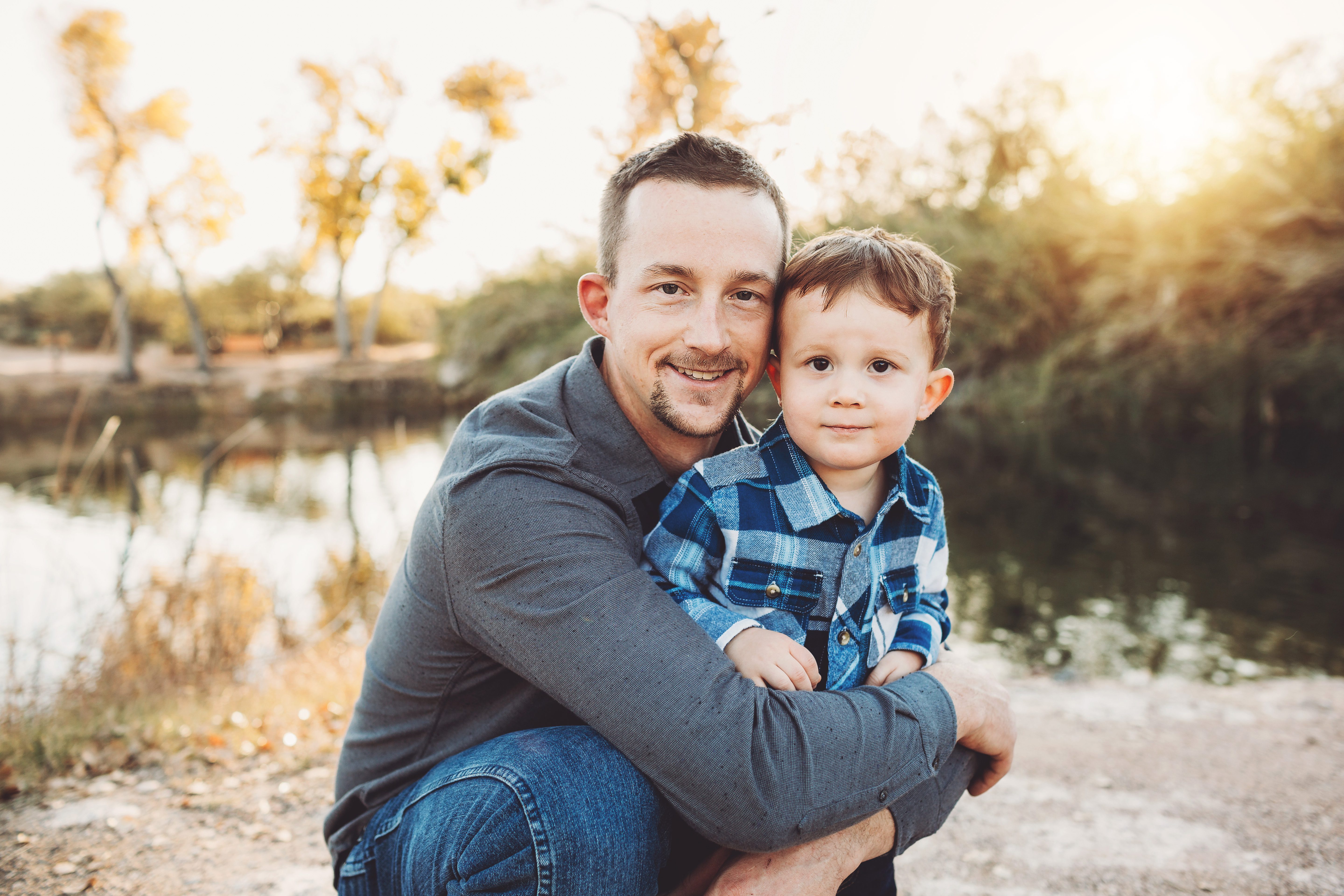 Dad Schlosser holds his oldest son close by the lake at Tanque Verde Guest Ranch during their family photo session