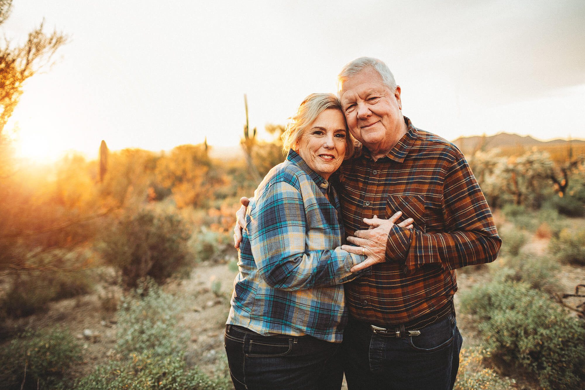 Mom & Dad snuggle together happily after many years of marriage, lovingly holding each other during the Lindley family photo session in Tucson