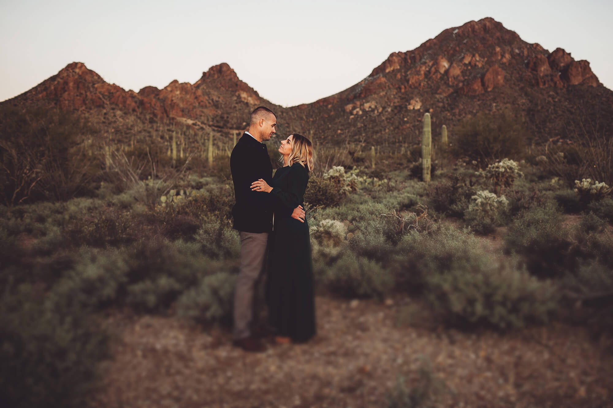 The Gunter's lovingly hold one another during the final moments of the day letting the setting sun and the peaks of Gates Pass surround them during the finals moments of their family photoshoot with Belle Vie Photography in Tucson