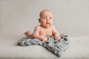 A very surprised look by a baby boy during his 3-month milestone session with Belle Vie Photography