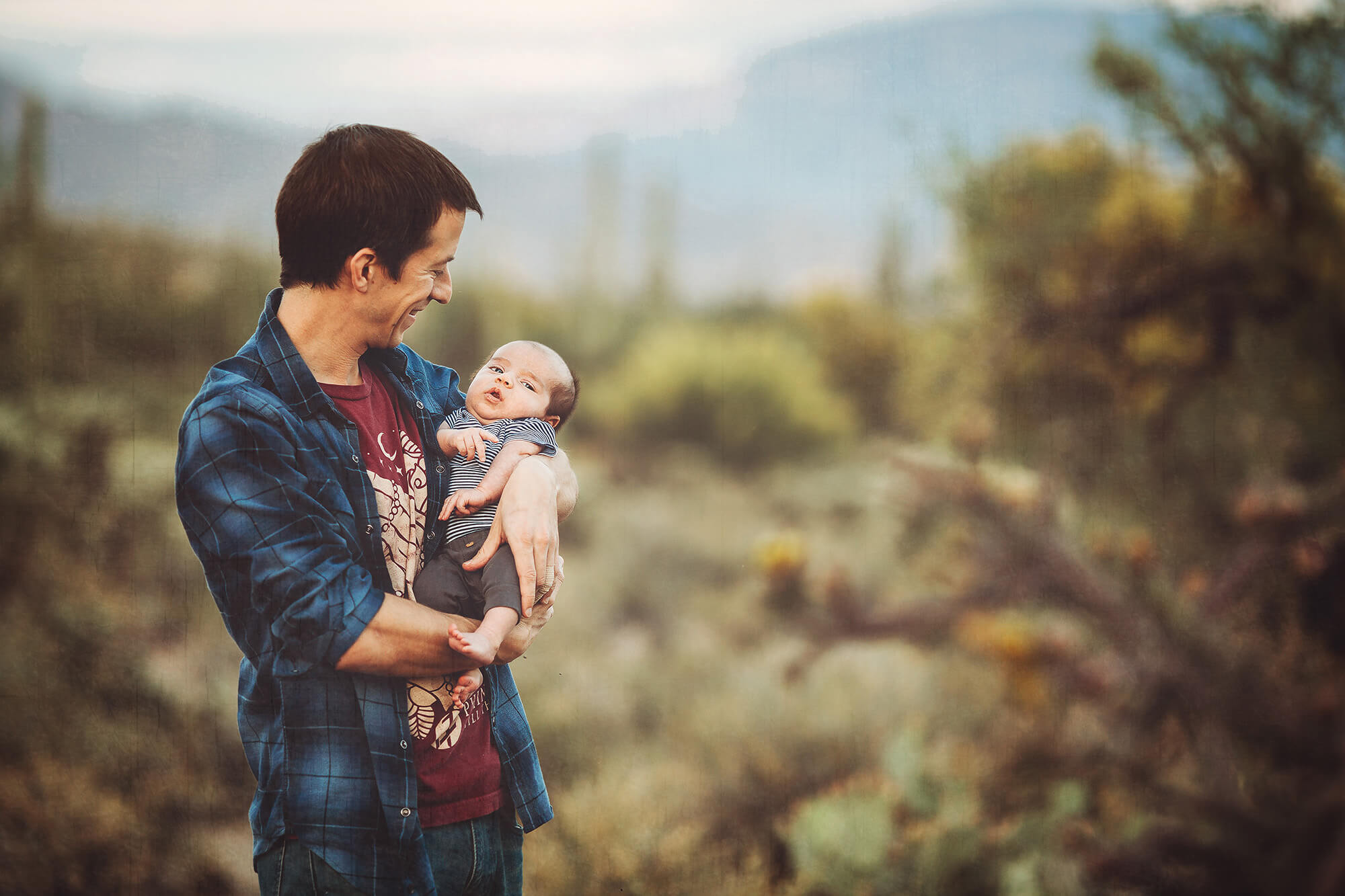Dad bounces his newborn baby boy to calm him during their cool spring family photo session.