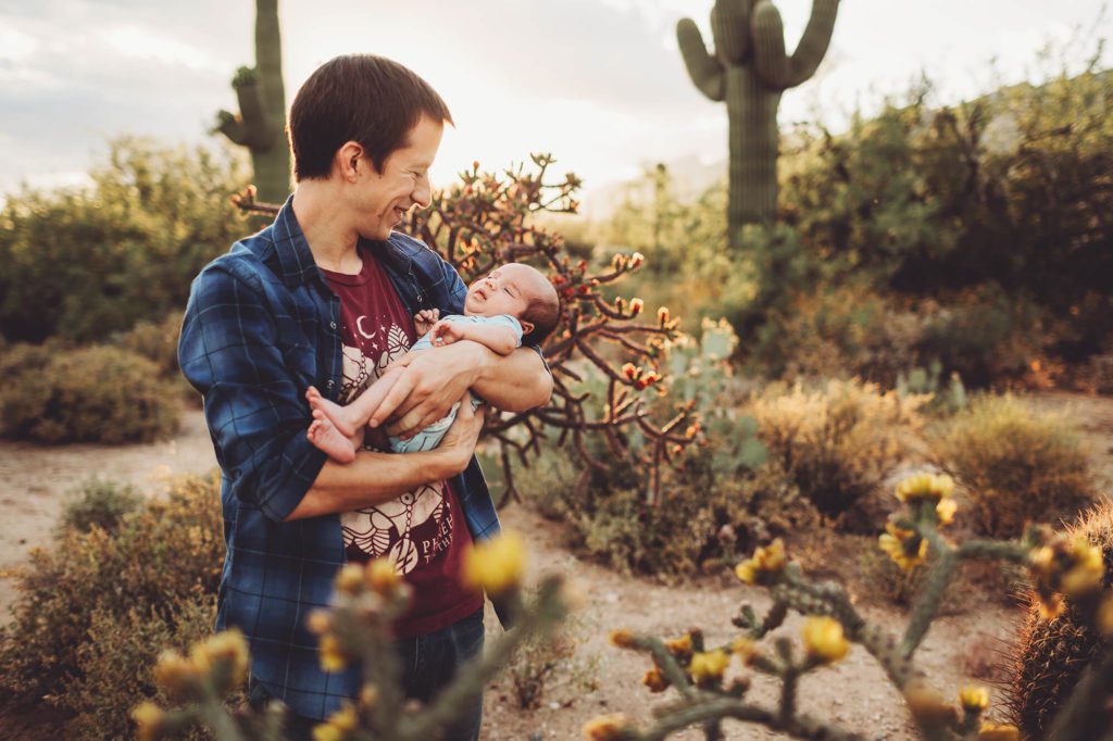Dad enjoys his newborn baby boy standing amongst the spring cactus blossoms at Sabino Canyon.