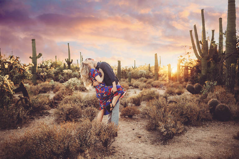 Shaun and Ally playfully embrace with the setting sun and a gorgeous Tucson sunset surrounded by saguaros at Sabino Canyon during their sunset engagement session with Tucson engagement photographer Belle Vie Photography