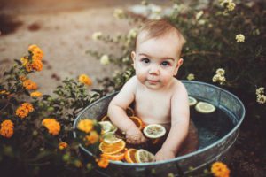 Baby Felix sitting in a cool fruit bath filled with fruit