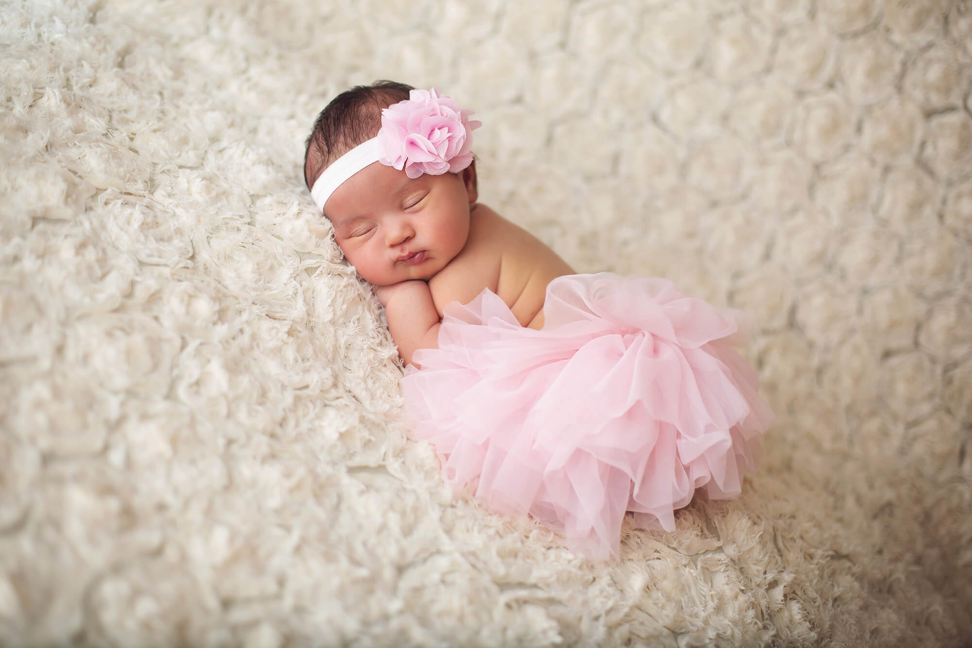 Wearing a pink tutu and headband, she is beautiful and all girl