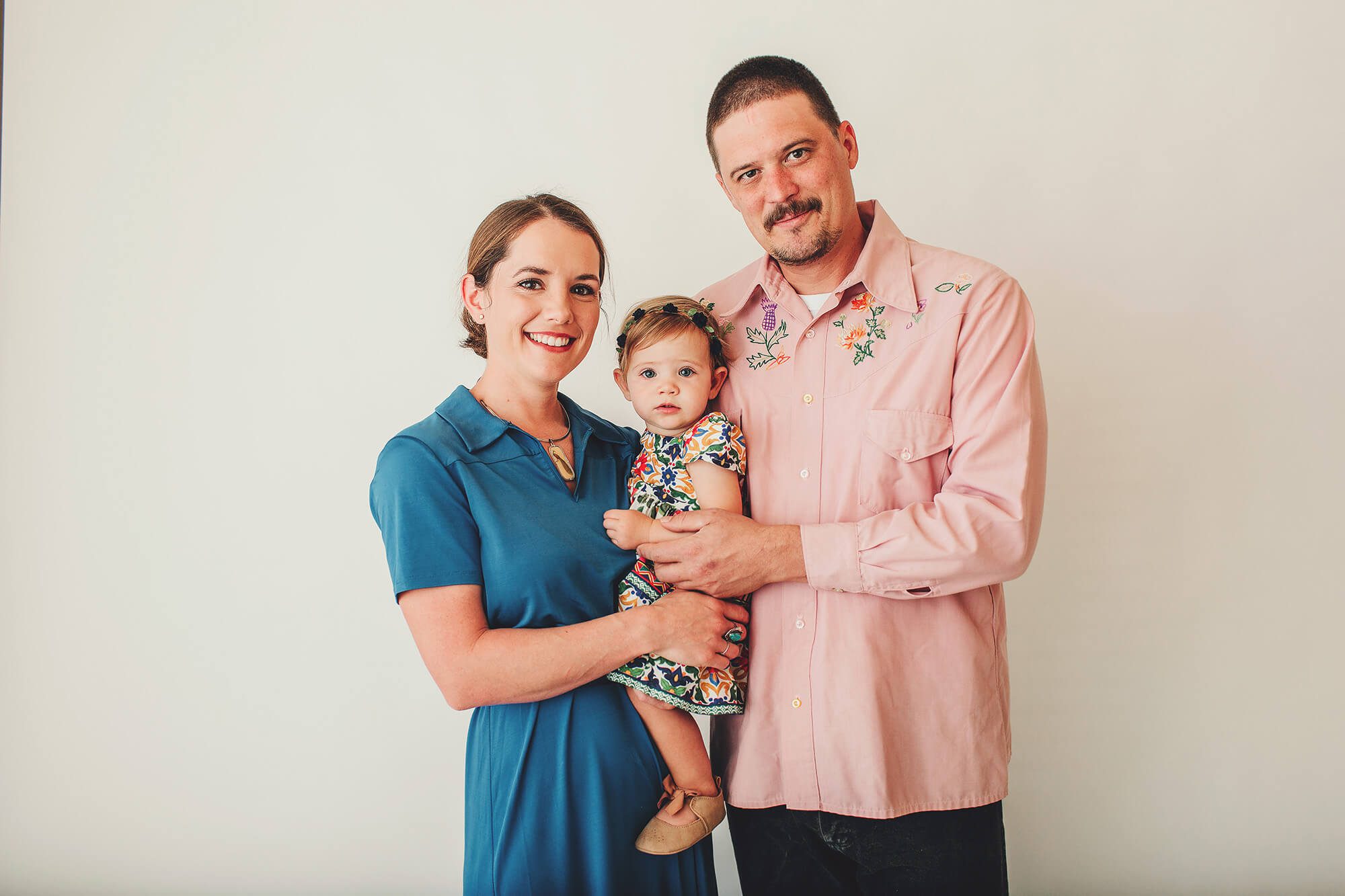 A little girl and her parents during her cake smash session