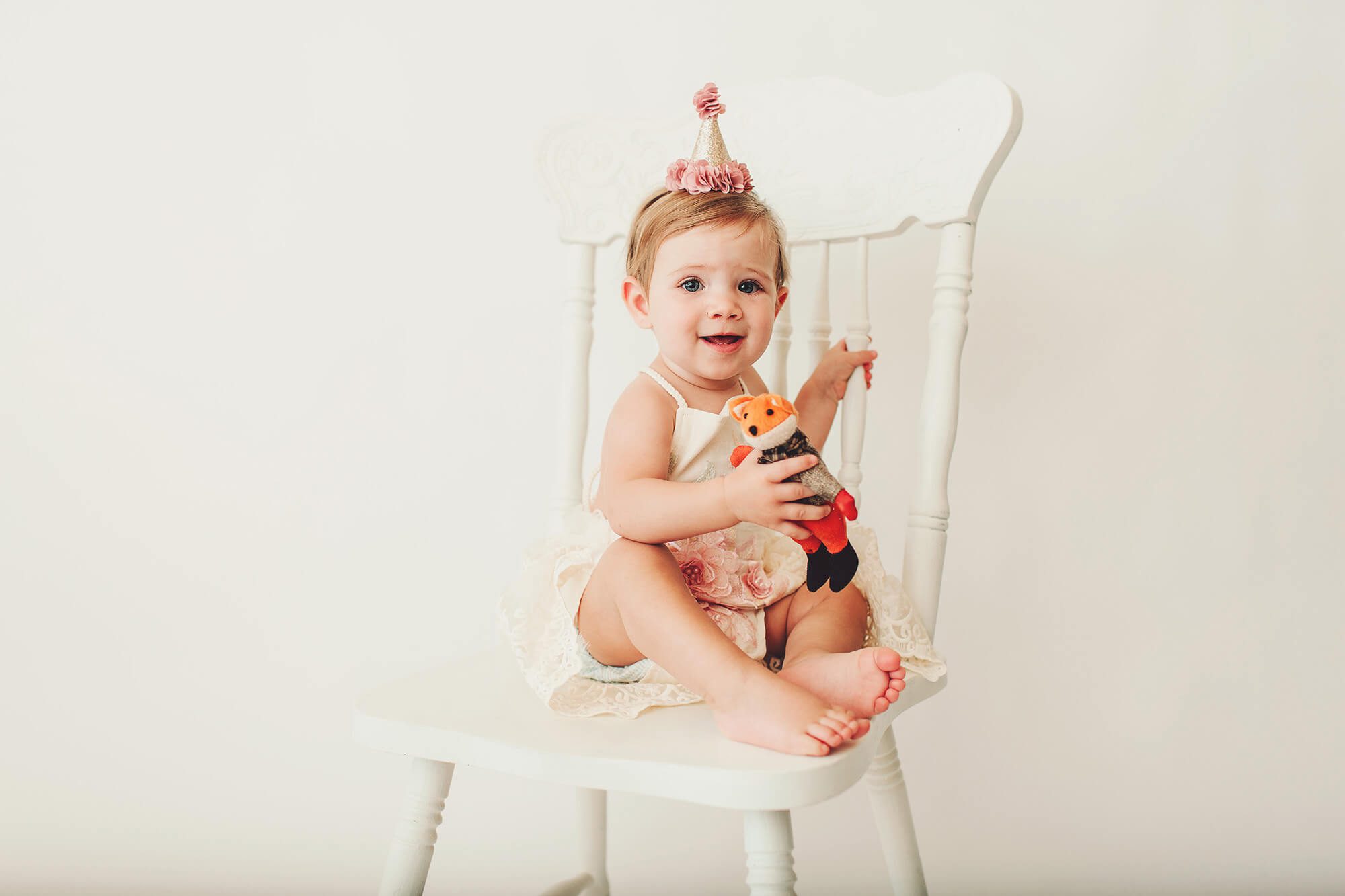 The birthday girl in a chair with her fox and birthday outfit