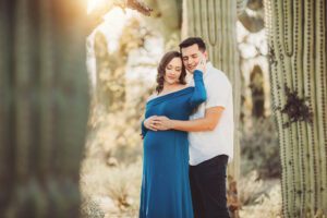 A gorgeous cuddle illuminated by the setting sun and saguaros during Adrianne and Eric's maternity session