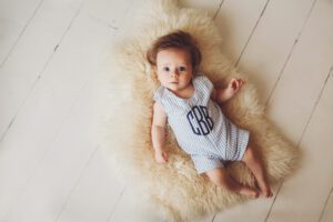 Sweet little boy in his monogrammed onesie during his three month session