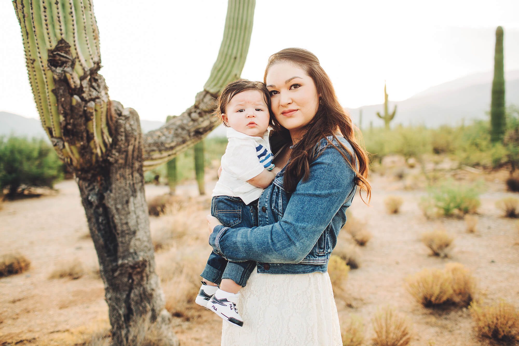 Alicia and Easton cuddling in front of a saguaro