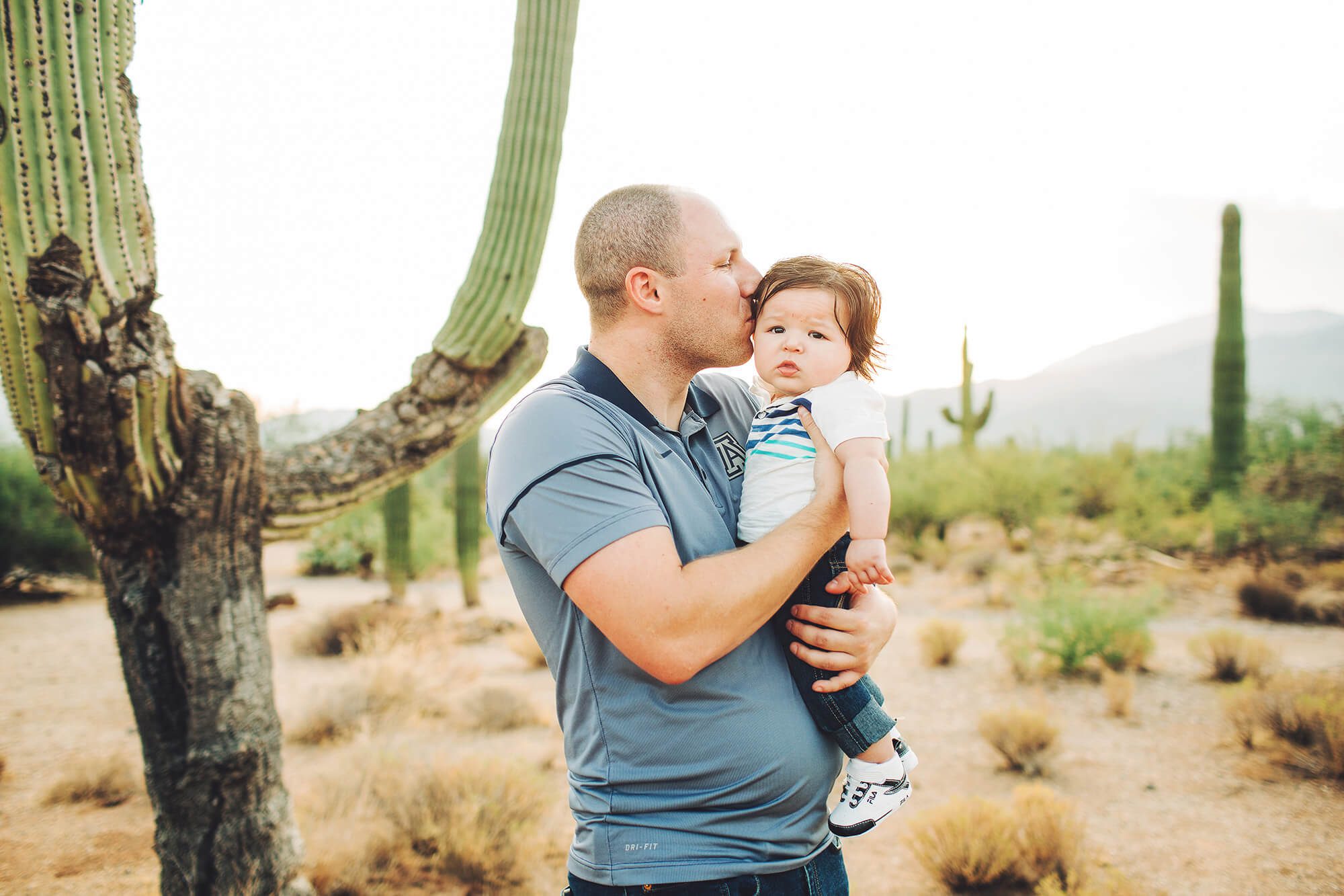 Daddy Stephen giving his son Easton kisses during their sunrise family session