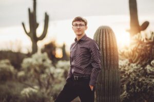 A closer up image of Cory at sunset surrounded by saguaros