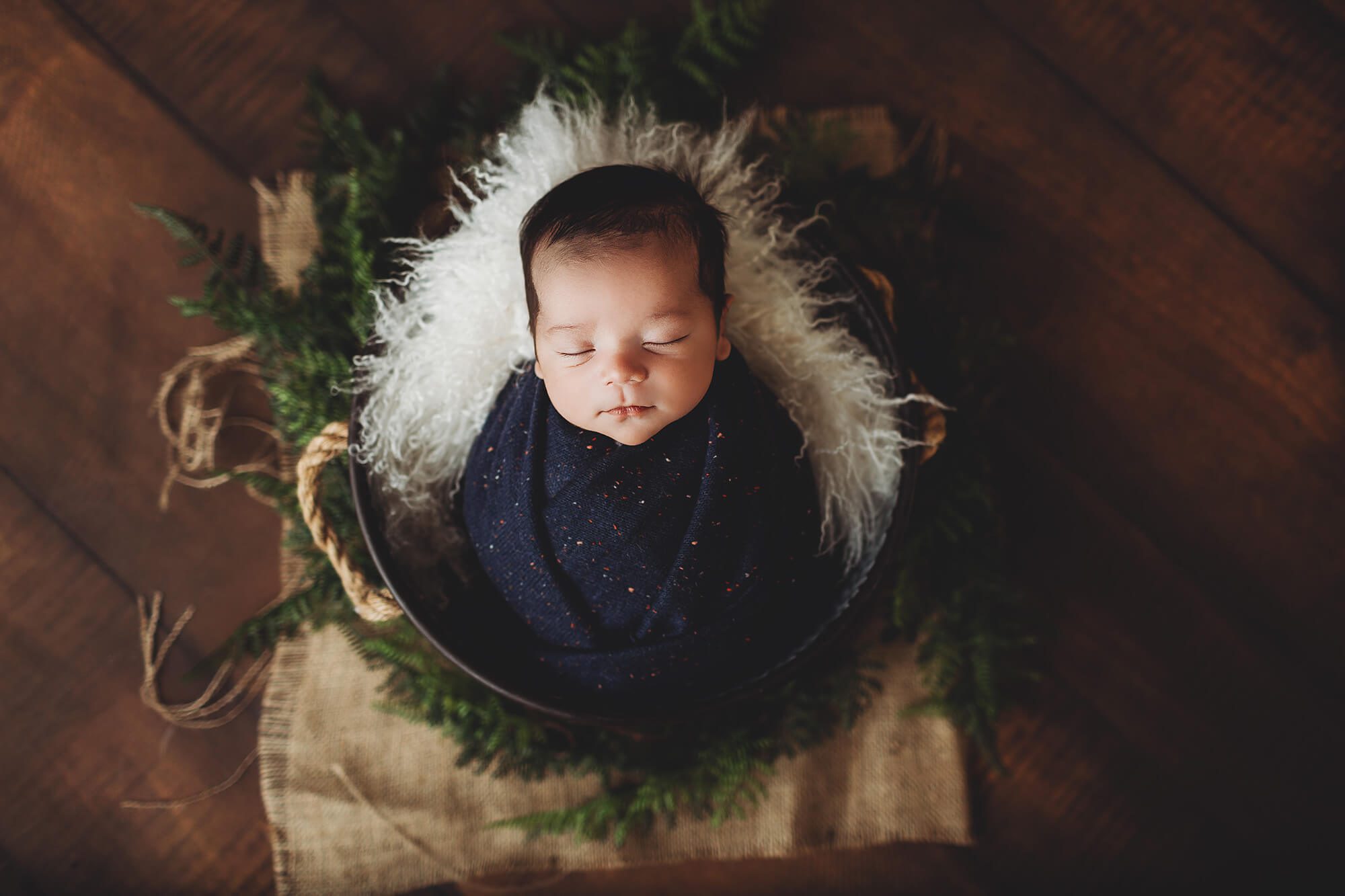 Baby O in a bucket surrounded by greenery