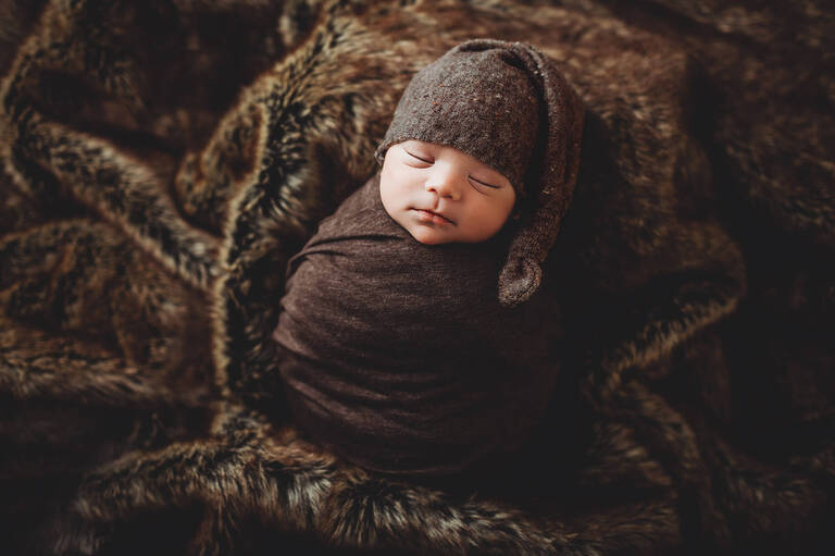 A brown sleep cap for a sleepy boy during his newborn session