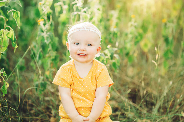 Sweet smiles for this little girl nearing her first birthday during the Tawney Family photo session.