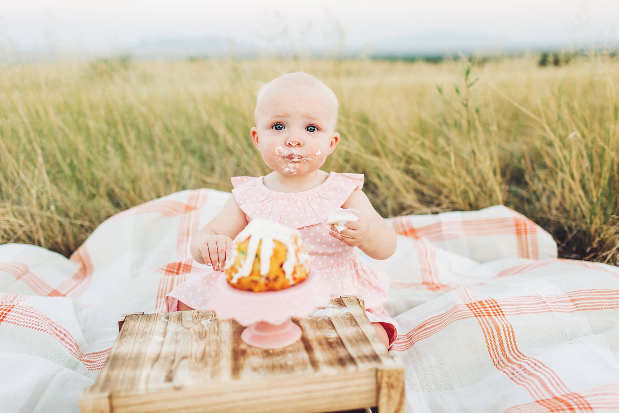 Loving her cake during this sweet girl's outdoor cake smash session